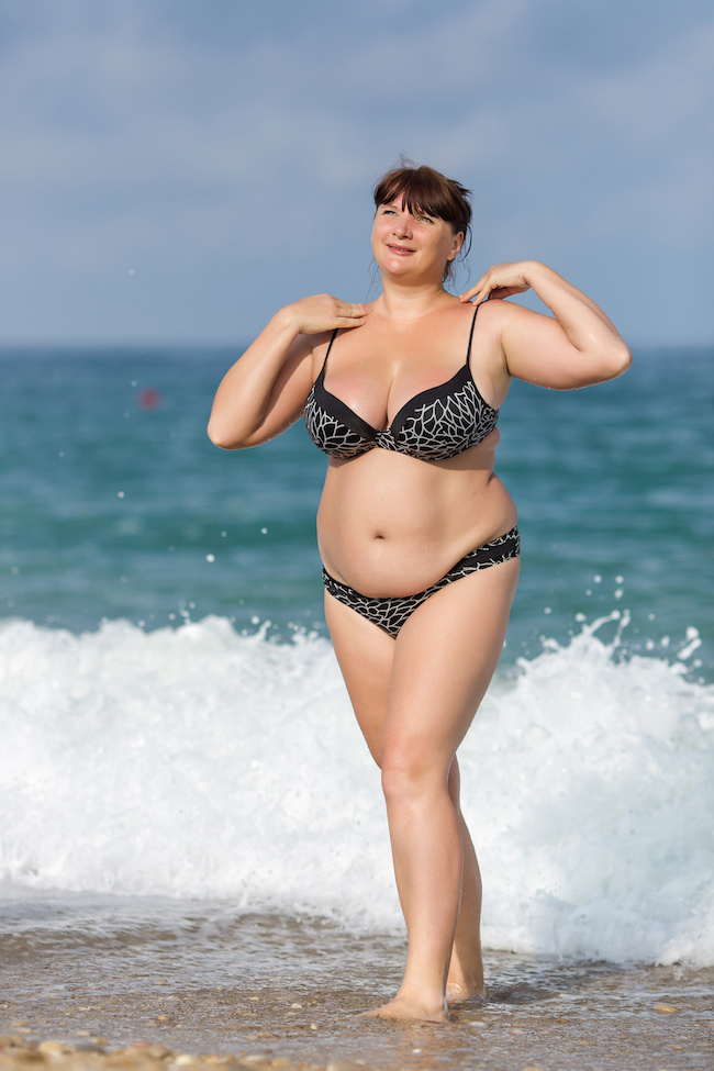 Overweight young woman at the sea